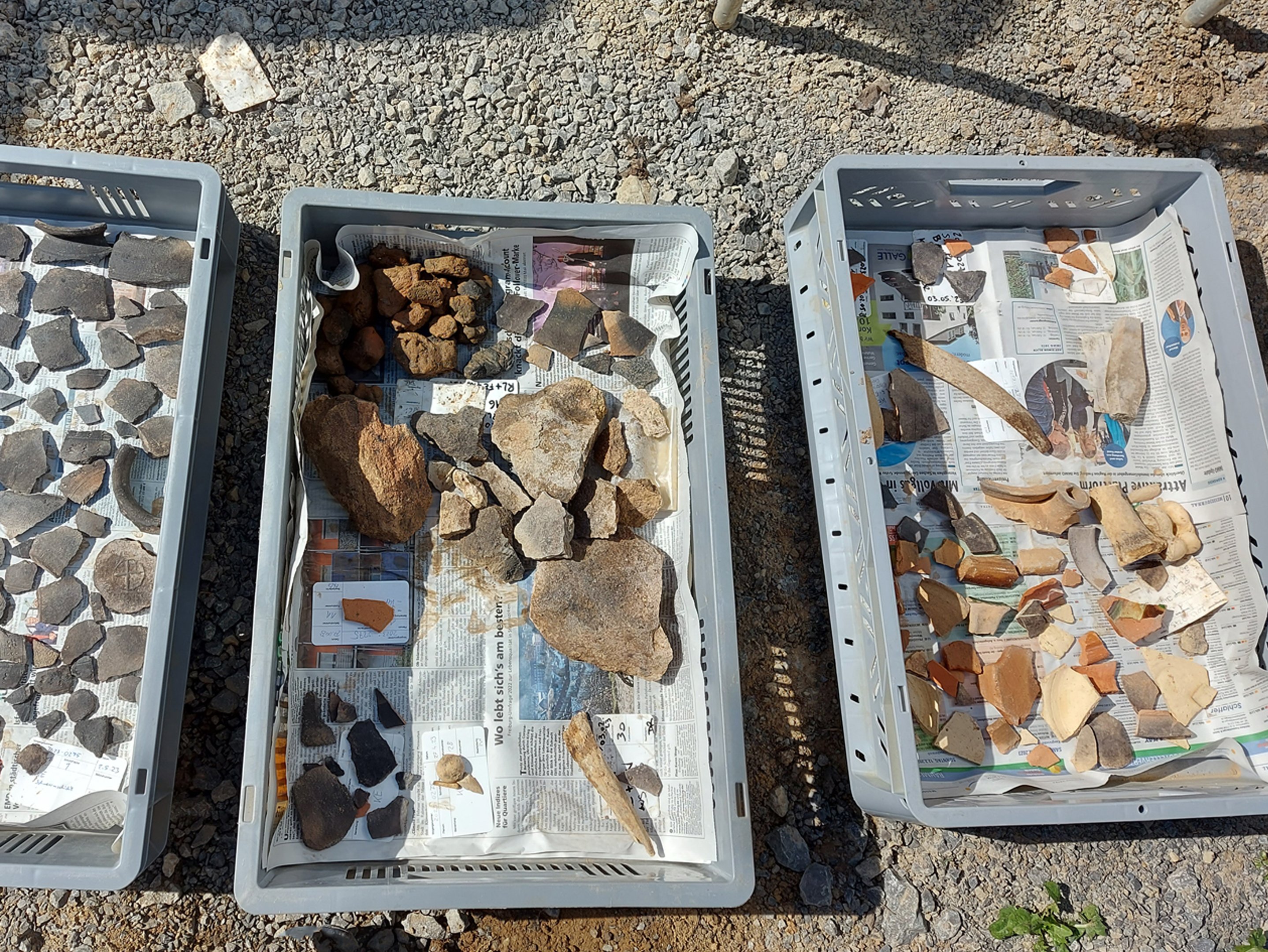 Ausgrabung: Fundstücke am Steppikreisel - Kisten mit Steinen, Knochen und Scherben